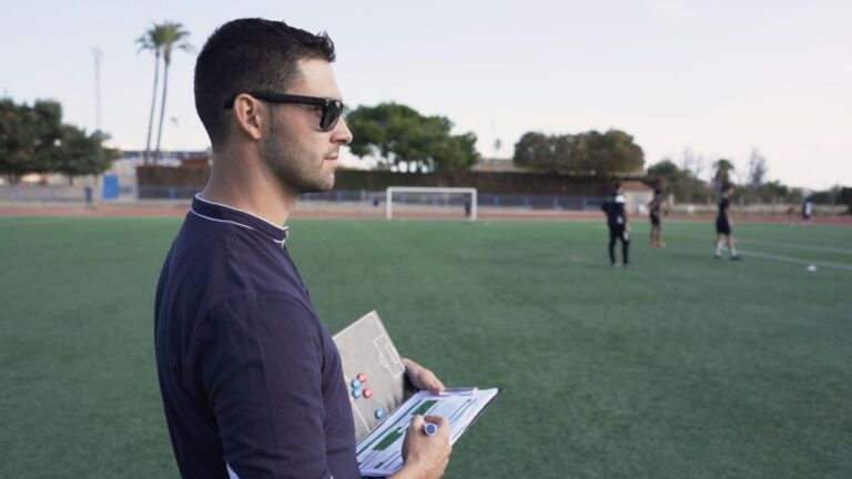 скаут смотрит футбольный матч с биноклем